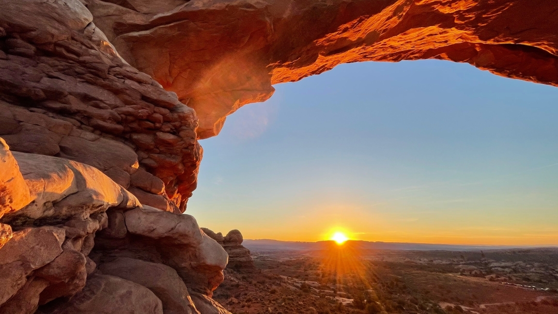 Image of the arch in Moab with the sun shining through
