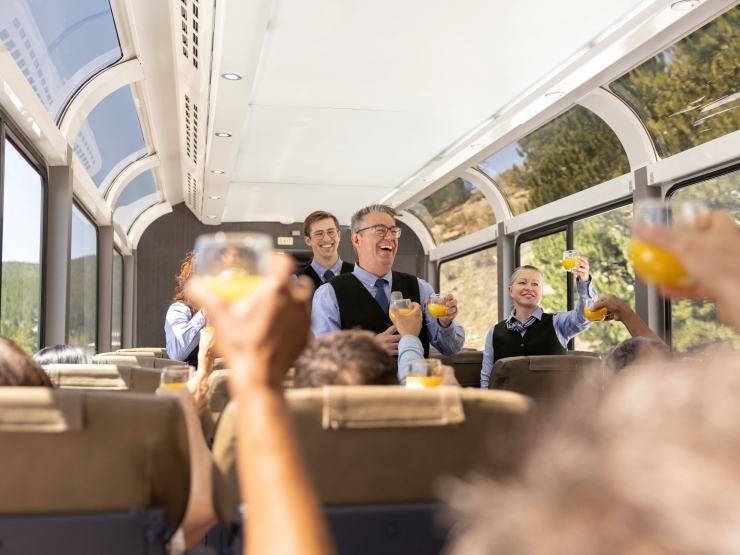 Image of multiple hosts raising their glasses with guests
