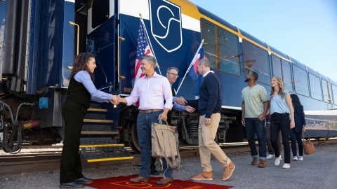 Hosts greeting guests and guests boarding the train