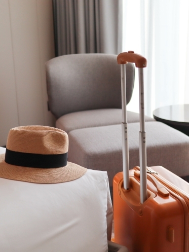 Image of a luggage and a hat in a hotel room